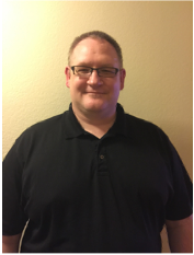A white man with short hair wearing glasses and black shirt